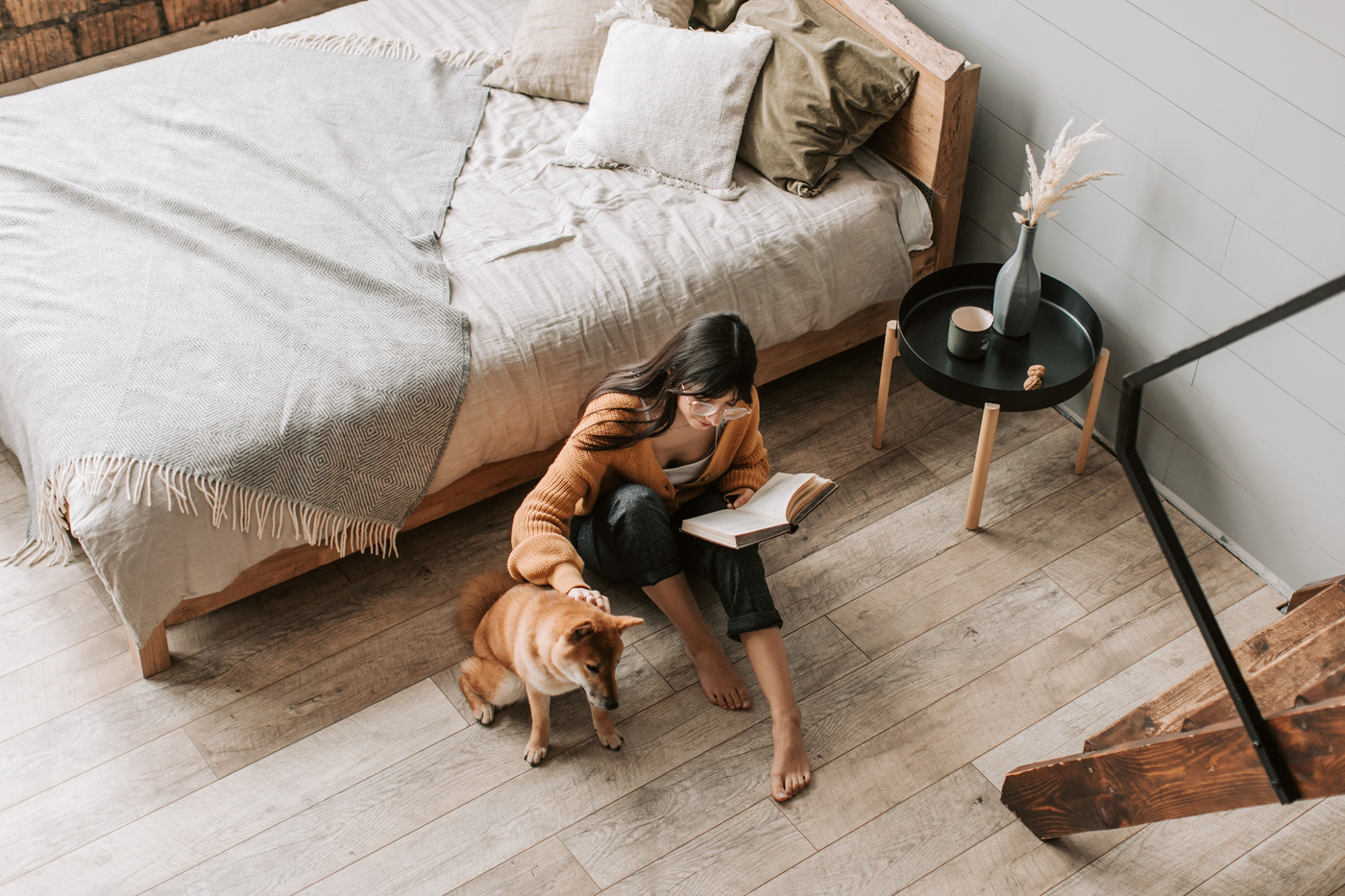 A Woman in Brown Sweater Sitting on the Wooden Floor
